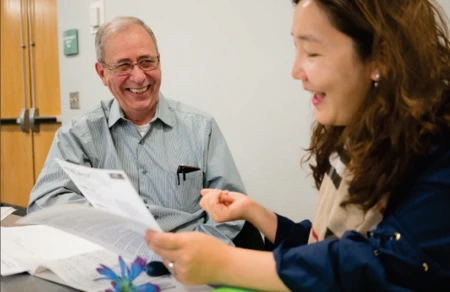 Two people lightheartedly discussing a paper
