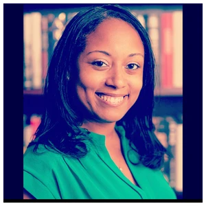 Photo of Shauntee Burns-Simpson in front of books
