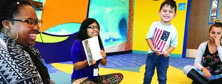 A group of young people sitting in a circle enjoying a book