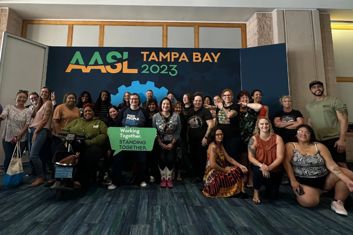 AASL Photo Booth in Tampa with a posed group of more than 30 members. smiling for the camera.
